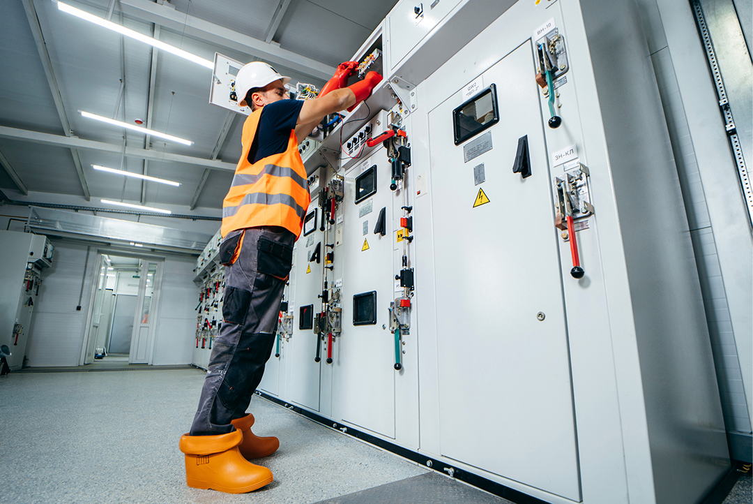Técnico vestido com os devidos EPI' realizando uma manutenção preventiva.